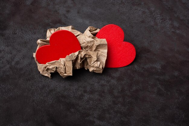 Two red heart icons in wrinkled paper Valentine love concept