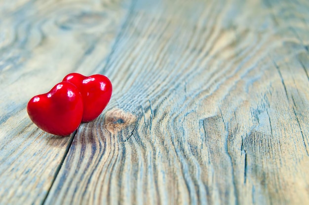 Two red hearts lie on a vintage texture board