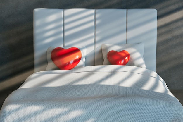 Two red hearts on a white soft bed in the bedroom on which the rays of the sun penetrate 3D render