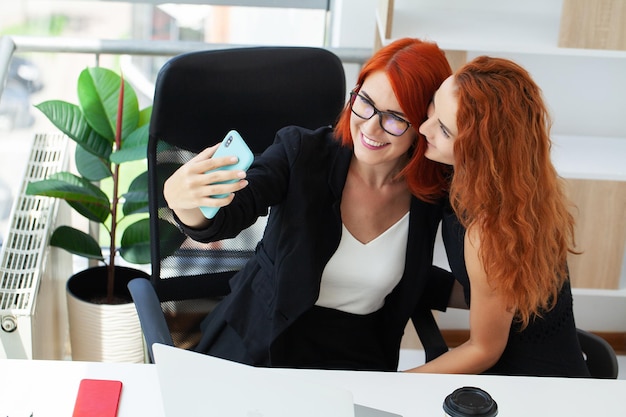 Two redhaired woman work together in the modern office