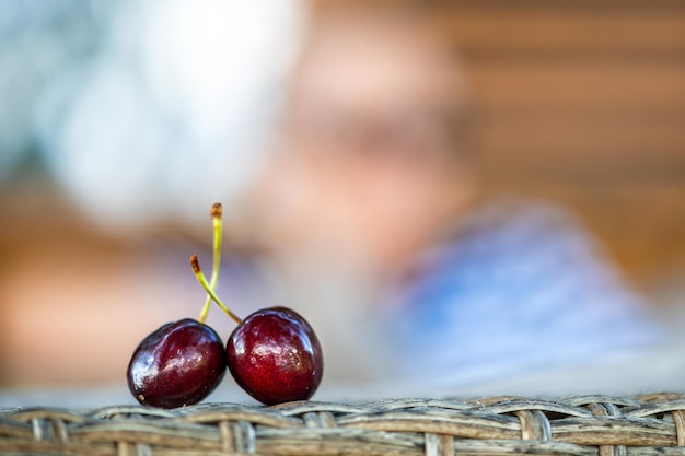 Two ripe red cherries on a defocused background closeup the concept of a romantic relationship