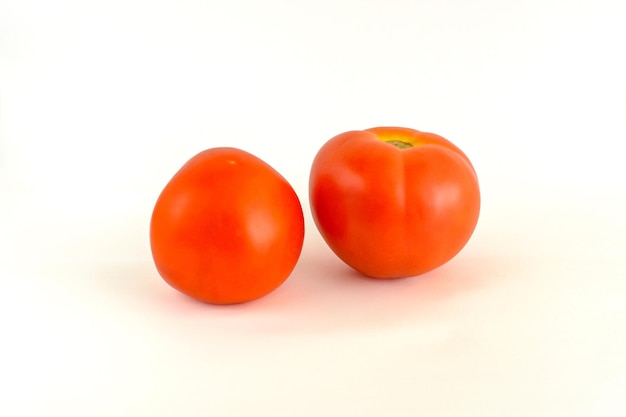 Two ripe tomatoes on a white background