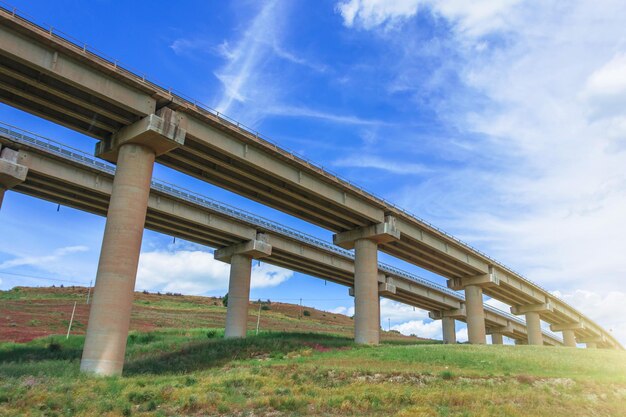 Two road turn highway bridge viaduct supports in the valley among the green hills transport infrastructure