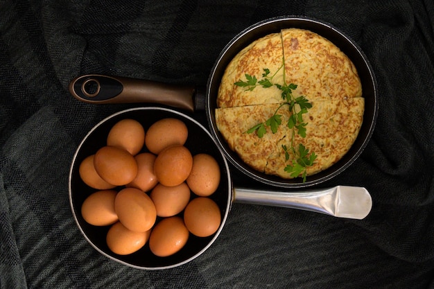 Two roasters in opposite directions with fresh eggs and an omelet divided into four parts