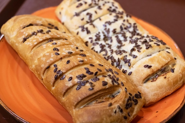 Two ruddy buns with sesame seeds on a plate