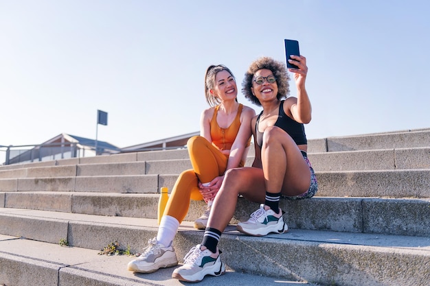 Two runner friends taking selfie with mobile phone