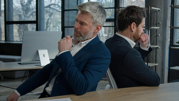 Two sad disappointed stressed worried caucasian businessmen men colleagues business partners