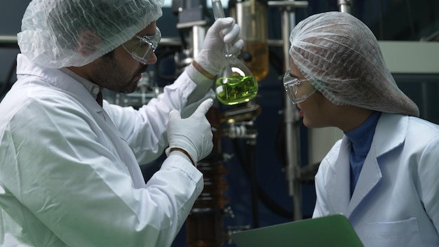 Two scientist in professional uniform working in laboratory