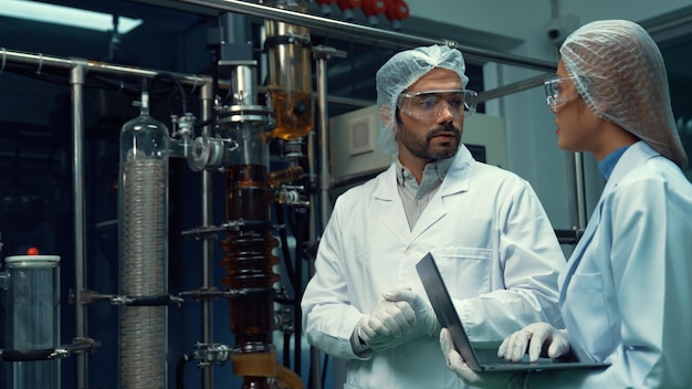 Two scientist in professional uniform working in laboratory