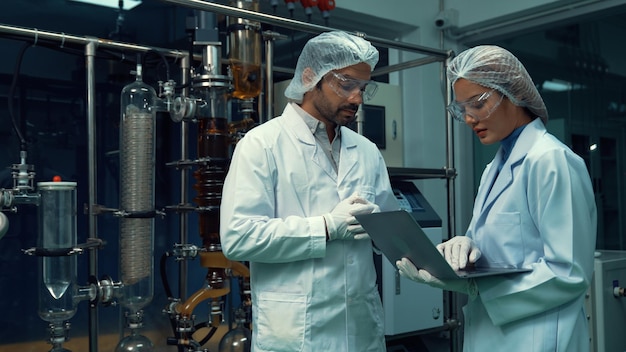 Two scientist in professional uniform working in laboratory