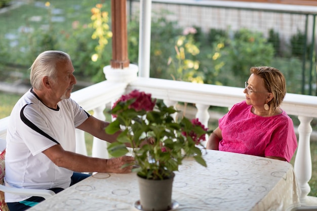 Two senior man and woman drinking coffee and smiling or discussing future plan after retire Mature couple drinking coffee on porch Retirement concept