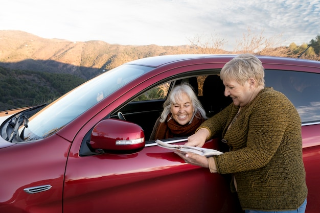 Two senior women consulting a map while out for a nature trip