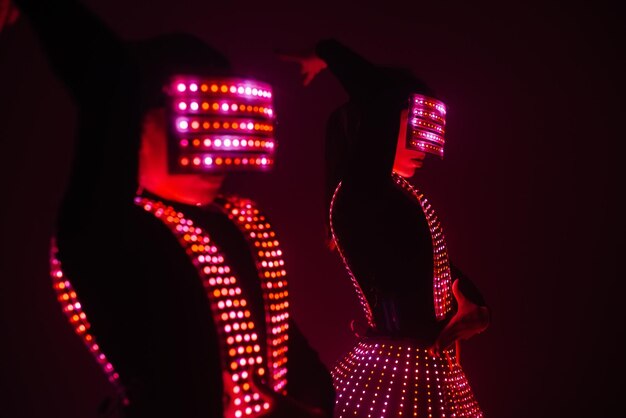 Two sexy disco dancers move in UV costumes. Parties and dances.