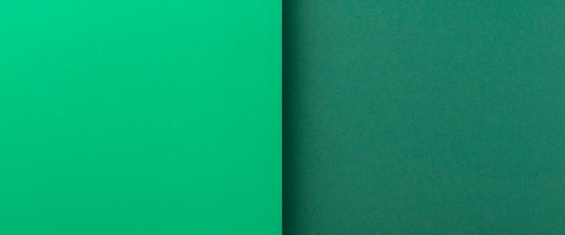 Two shades of green cardboard background. Top view, flat lay. Banner.