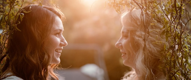 Two sister closeup portraits at sunset Women looking at each other