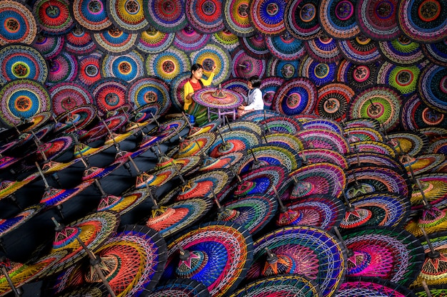 Two sisters doing traditional Burmese umbrellas Colorful umbrellas at the street market in Bagan, Myanmar (Burma). Burmese umbrellas