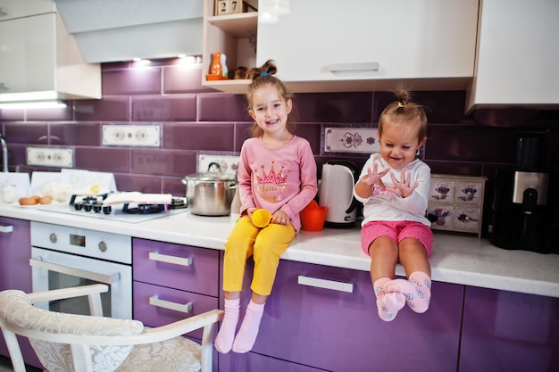 Two sisters kids cooking at kitchen happy children's moments