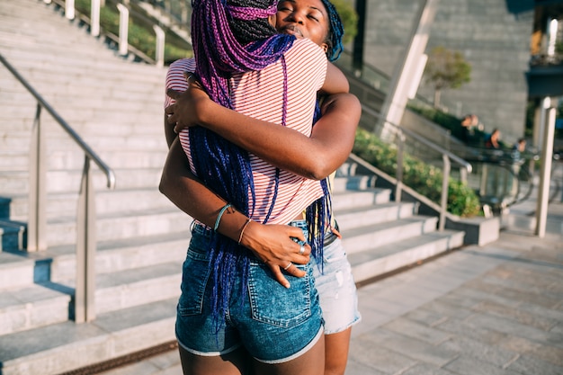 Two sisters outdoor hugging smiling