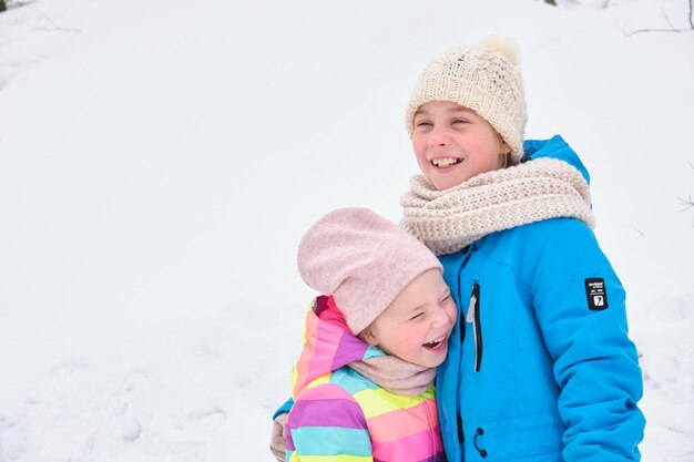 Two sisters play cute outside on a winter day