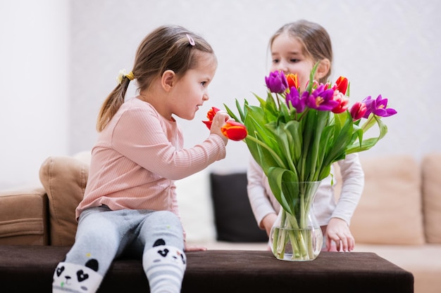 Two sisters with spring tulip bouquet Holiday decor with flowers colorful tulips