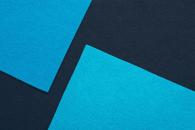 Two sky blue felt texture angled sheets over dark abstract background Minimalist geometric collage Empty space