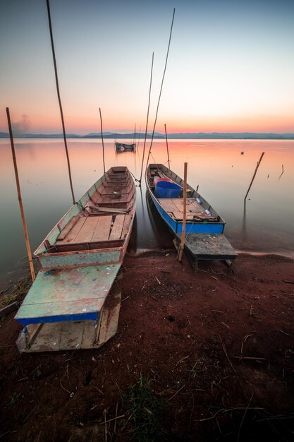 Two small boats moored on the shore of the lake. at sunset beautiful light