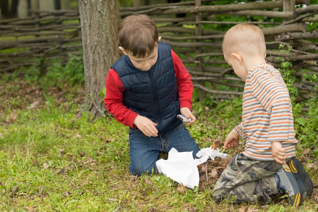 Two small boys trying to light a fire