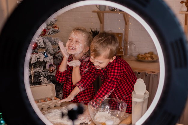 two small children cook a pie for Christmas and shoot a cooking blog. children bloggers