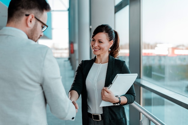 Two smiling business people handshake. Good business deal.