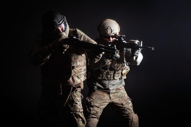 Two soldiers in military uniform with weapons in a special operation at night