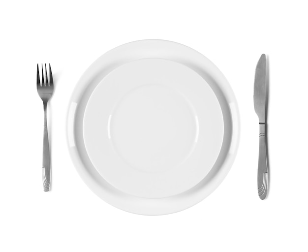 Two stacked white plates with fork and knife isolated on white background