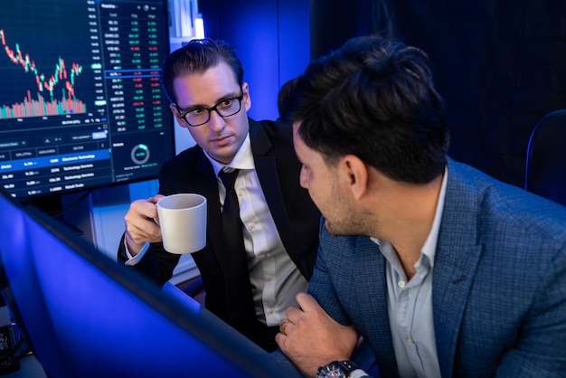 Two stock exchange traders discussing dynamic investment graph Sellable