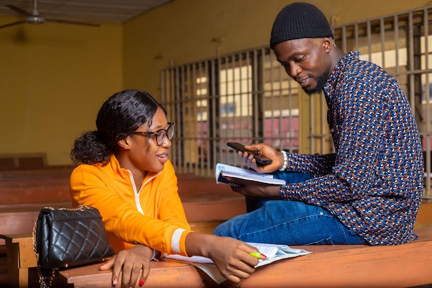 Two students reading a book together in classroom