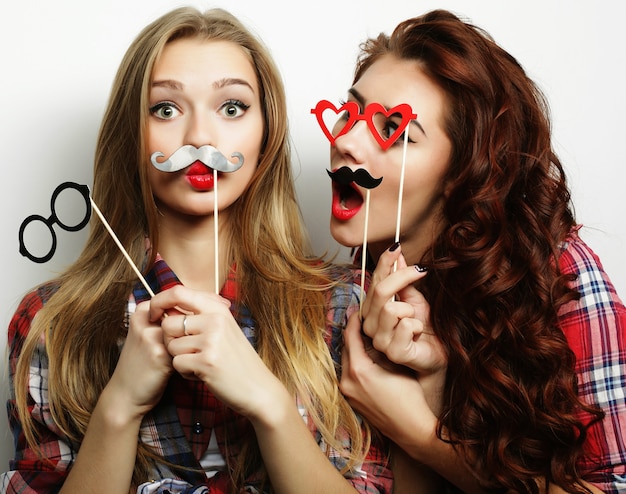 Two stylish sexy hipster girls best friends ready for party, over gray background