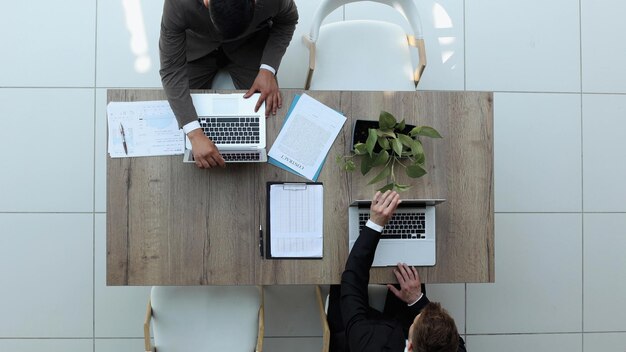 Two successful smiling businessmen are working on a laptop view from above