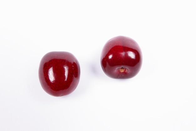 Two sweet juicy red cherries isolated on a white background View from above Healthy food concept