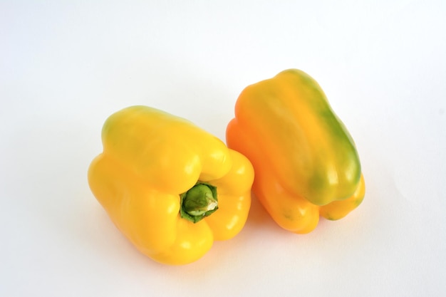 two sweet yellow peppers isolated on white background, close-up