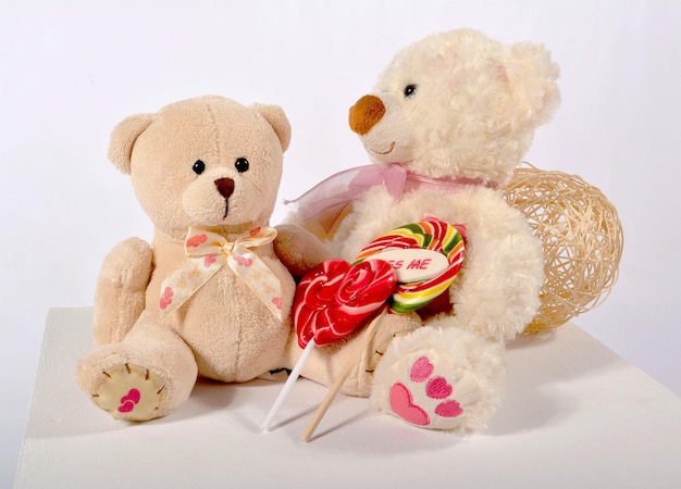 Two teddy bears with two candy