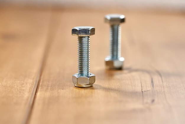 Photo two thread screws on a wooden table.