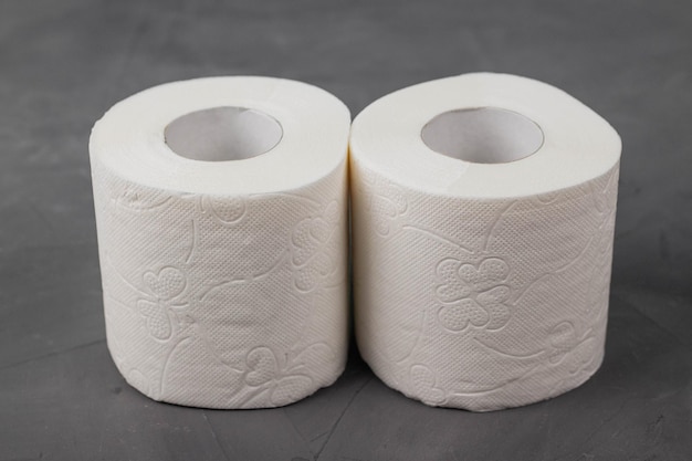 Two toilet paper rolls on a gray background