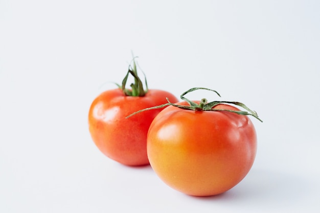 Two tomatoes isolated on a white background, tomato close-up