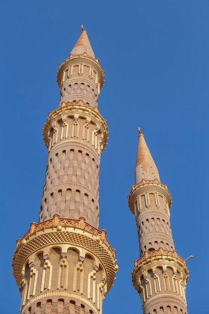 Two towers of the AlSahaba Mosque against a blue sky in Sharm el Sheikh Egypt Architecture of Al Sahaba Al Mustafa mosque in old town