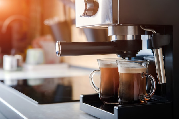 Two transparent cups closeup front view Home coffee maker and process of making coffee drink