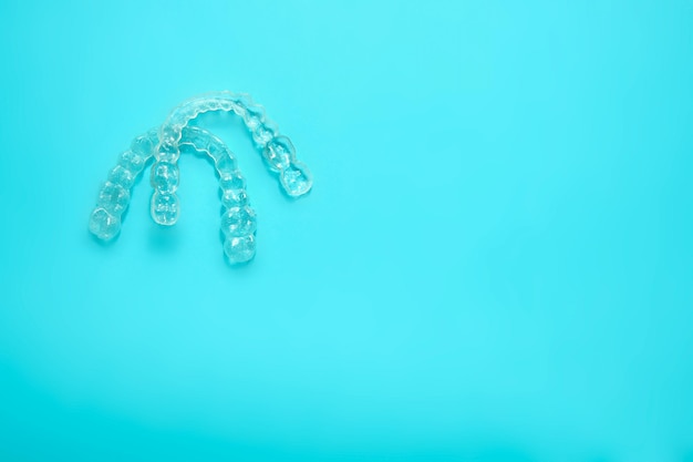 Two transparent dental retainers on blue background