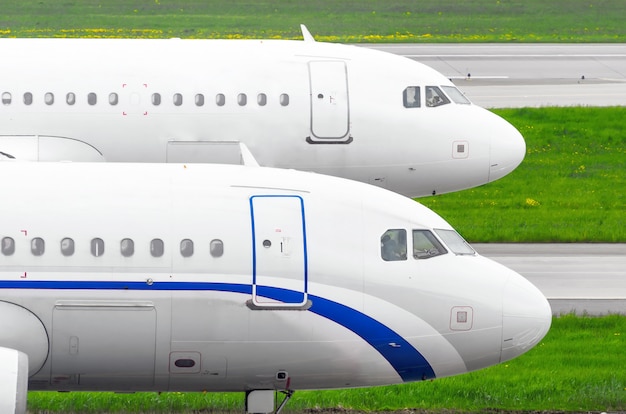 Two twin airplanes on the runway at the airport