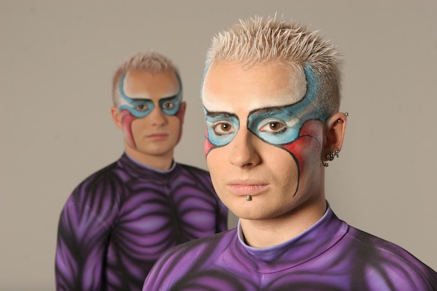 Two twins with white hair in tight purple suits posing for the camera, super heroes