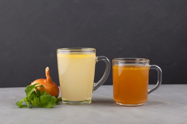 Two types of bone broth in transparent cups