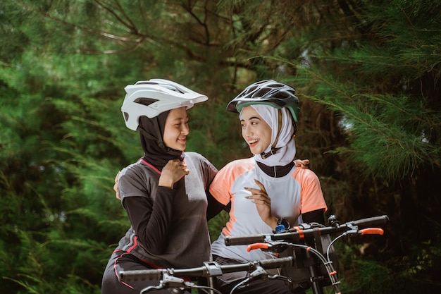 Two veiled girls chatting while enjoying cycling together