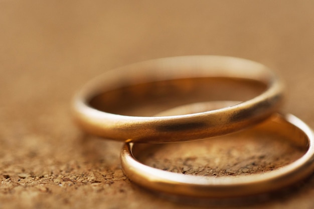 Two wedding rings on a cork table background with shallow DOF