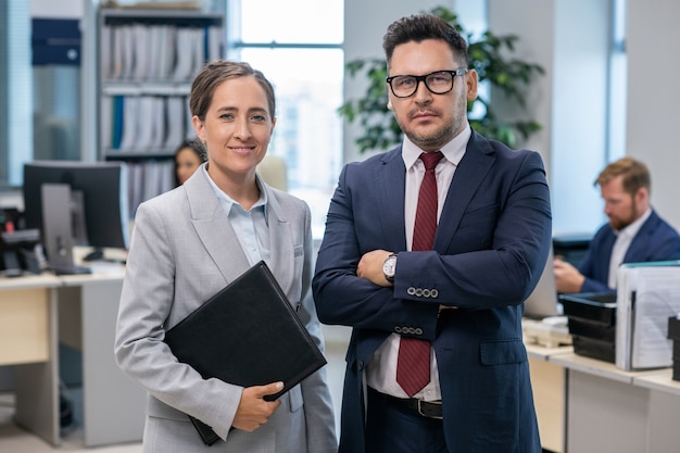 Two welldressed employees standing in front of camera